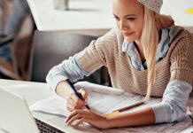Die Qual der Wahl nach dem Studium Junge Frau sitzt am Schreibtisch mit Laptop und Stift und Papier.
