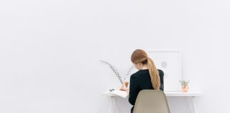 Eine junge Frau sitzt an ihrem Schreibtisch und arbeitet.