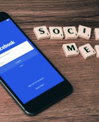 Facebook-App auf Smartphone und Scrabblesteine Social Media
