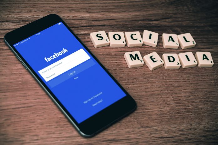Facebook-App auf Smartphone und Scrabblesteine Social Media