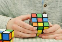 Ein junger Mann löst einen Rubik's Cube.