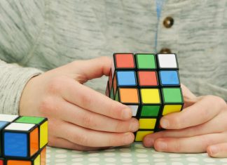 Ein junger Mann löst einen Rubik's Cube.
